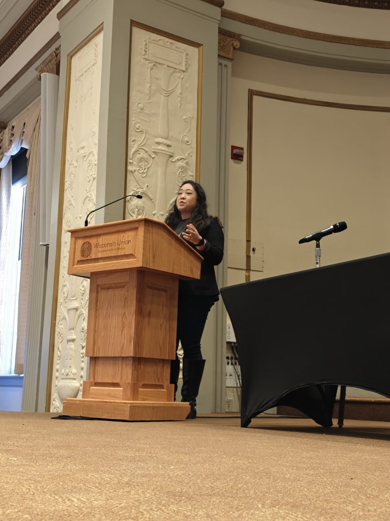 Presenter onstage behind podium before panel discusssion